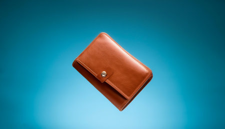 Leather wallet floating or flying isolated on light blue backgroundの写真素材