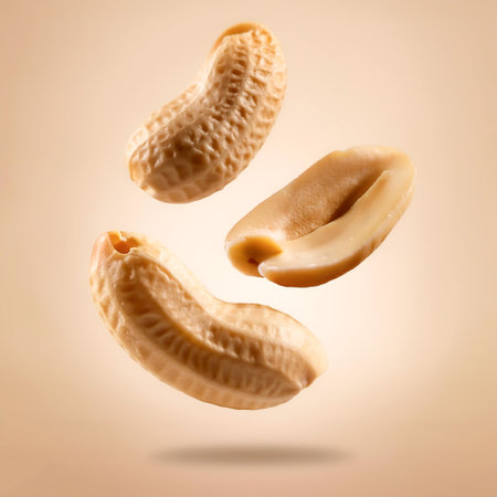 peanuts slices floating or flying isolated on biege backgroundの写真素材