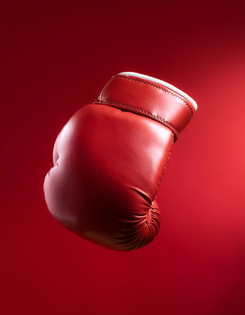 Red leather boxing glove floating or flying isolated on Clean Red backgroundの写真素材