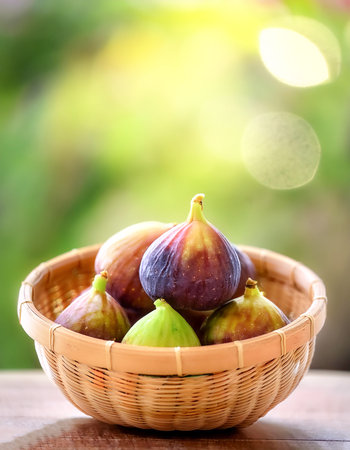 Figs Fruit in Bamboo basket with blur green bokeh background