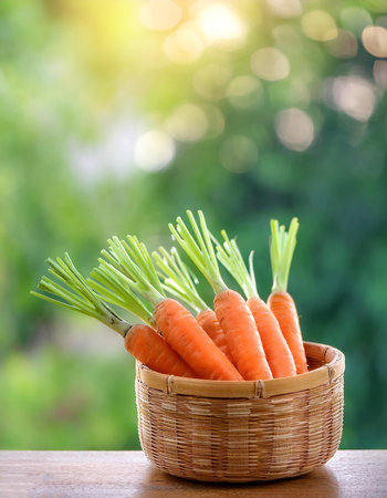 Carrot Vegetables in Bamboo basket with blur green bokeh backgroundの写真素材