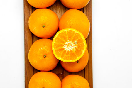 Citrus fruits are neatly arranged on a wooden tray, showing off their freshness. Showing off their juicy texture, emphasizing the organic and nutritious qualities of these delicious citrus fruits.の写真素材