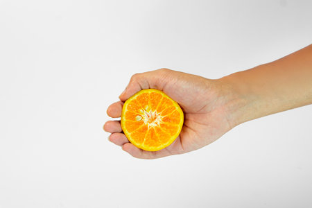 A hand holding a fresh, juicy orange slice, showcasing its vibrant color and texture. Perfect for healthy snacking or adding zest to dishes.の写真素材