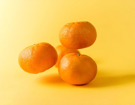a pile of Oranges on a bright yellow backgroundの写真素材