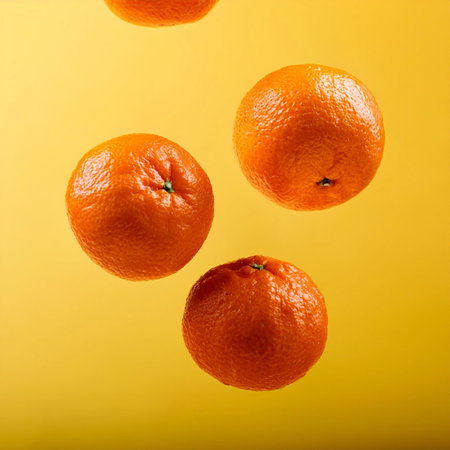 Flying mandarin oranges on a bright yellow backgroundの写真素材