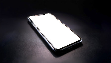 Smartphone with white screen, isolated on a dark blackの写真素材
