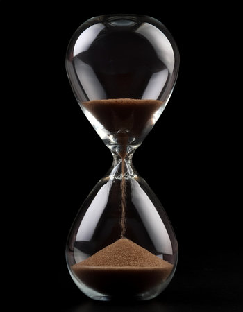 Hourglass sandglass, isolated on a dark blackの写真素材