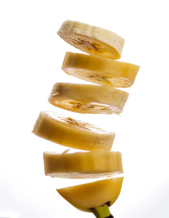 banana slices or chunks floating or flying isolated white backgroundの写真素材