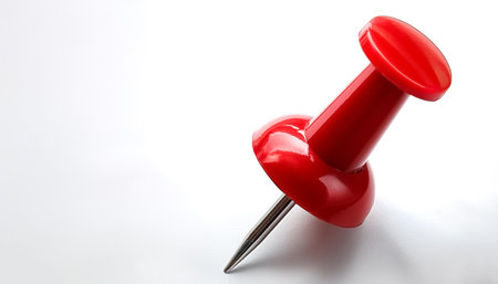 A single bright red push pin with a metallic needle on side position provides copy space for text. background concept isolated whiteの写真素材