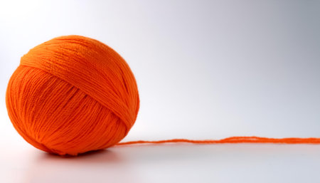 a Vibrant orange yarn ball on side position provides copy space for text. background concept isolated whiteの写真素材