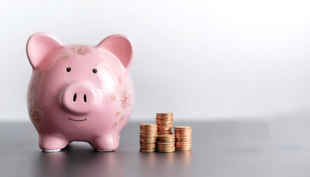 pink flowered piggy bank with coin on side position provides copy space for text. background concept...