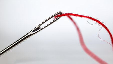 Sewing needle with red threadの写真素材