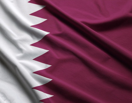 State of Qatar flag waving in the wind. Close up of State of Qatar flag banner blowing, soft and smooth silk. Cloth fabric texture ensign background. Use it for national day and country occasions conceptの写真素材