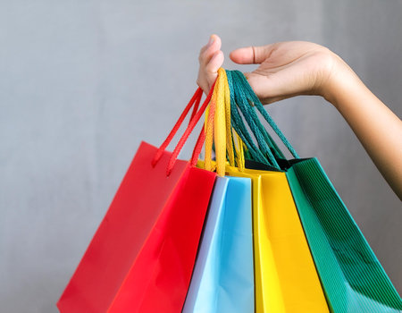 Female hand holding many colorful shopping bags, template. Mockupの写真素材