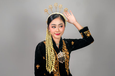 Portrait of an elegant Asian woman wearing traditional Javanese attire, smiling with a charming...