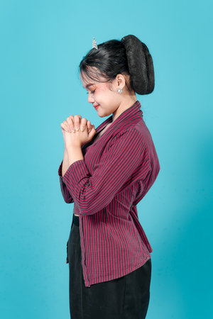 portrait of a young woman smiling peacefully with closed eyes and hands clasped, radiating calmness, gratitude, and serenity in an elegant and composed expression.の写真素材