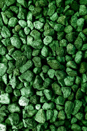 Close-up of textured green gravel stones forming a rough and organic background. The vivid green tone creates a fresh, bold, and natural aesthetic, ideal for modern design and branding.の写真素材