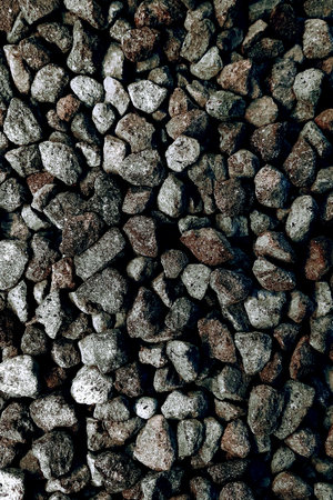 Detailed close-up of coarse gravel stones in earthy gray and brown tones, showcasing a natural and...
