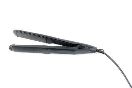 Sleek black hair straightener with ceramic plates for smooth and shiny hair. Features fast heating, ergonomic grip, and a swivel cord, perfect for professional and home stylingの写真素材