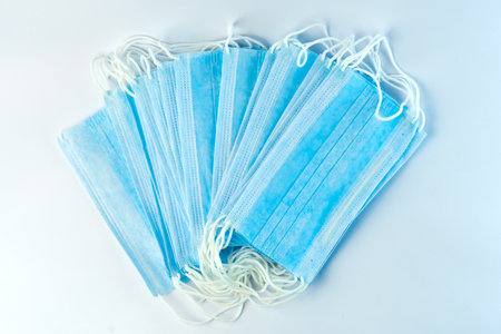 Disposable blue surgical face masks with ear loops for daily protection. Made from non-woven fabric,...