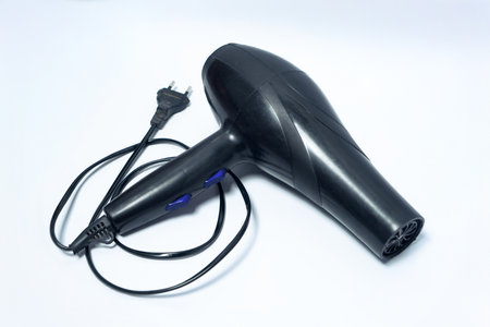 Black electric hair dryer with ergonomic handle, blue control buttons, and attached power cord...