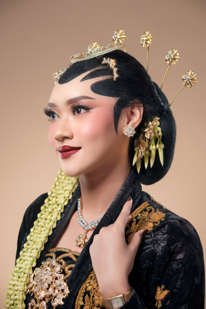 Indonesian woman in elegant Javanese bridal attire, featuring paes makeup, jasmine garlands, ornate...