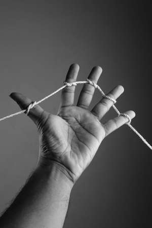 a hand with all fingers tied with a ropeの写真素材