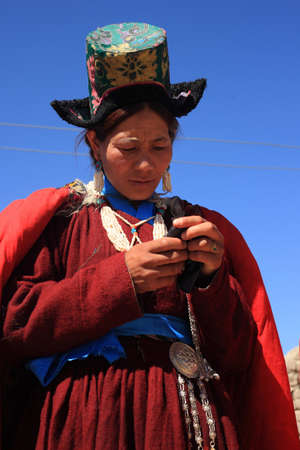 LEH, INDIA - SEPT 01 ,2012- An unidentified Ladakhi tribal woman checks her phone as she participates in the cultural procession during Ladakh Festival  in Leh, India.のeditorial素材