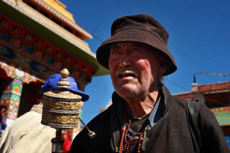 LEH, INDIA - SEPT 01, 2012-An unidentified Ladakhi Buddhist man holding a prayer wheel participates in the cultural procession during Ladakh Festival  in Leh, India.のeditorial素材
