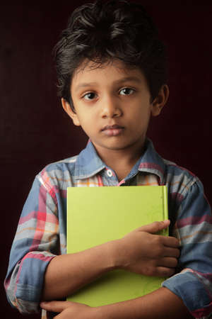 Portrait of a little boy holding a book