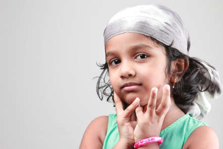 Portrait of a little girl a fashion cloth tied over headの写真素材