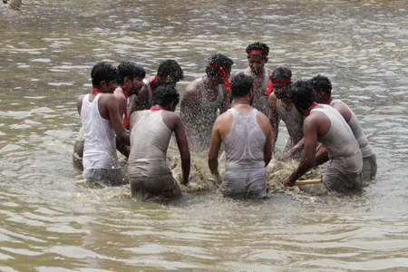 OCHIRA, INDIA - JUNE 17,2015- Devotees take part in the 'Ochira Kali' a ritualistic martial art festival played in the pond water at Ochira Parabrahma temple in Ochira , Kerala, India.のeditorial素材