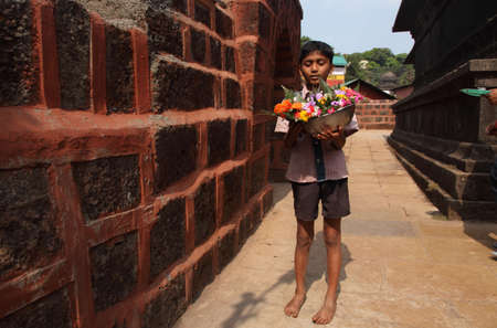 PUNE, INDIA - APR 24, 2011-Unidentified vendors sell flowers in front of a temple in Pune, Maharashtra, India. Its custom ritual to offer flowers to deity in Hindu temples in India.のeditorial素材