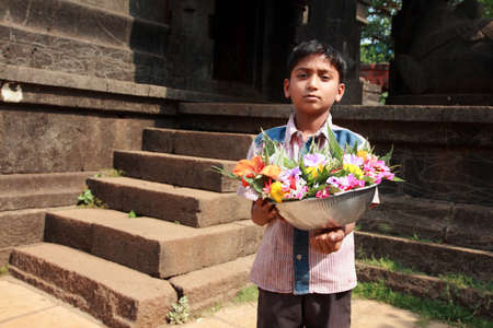 PUNE, INDIA - APR 24, 2011-Unidentified vendors sell flowers in front of a temple in Pune, Maharashtra, India. Its custom ritual to offer flowers to deity in Hindu temples in India.のeditorial素材