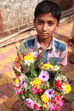 PUNE, INDIA - APR 24, 2011-Unidentified vendors sell flowers in front of a temple in Pune, Maharashtra, India. Its custom ritual to offer flowers to deity in Hindu temples in India.のeditorial素材