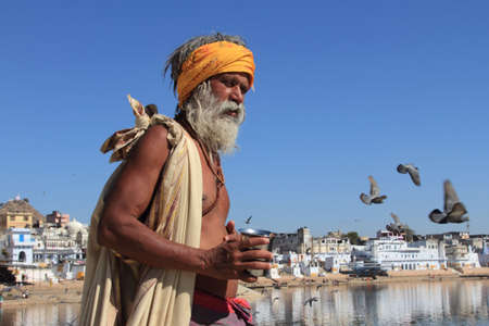 PUSHKAR, INDIA - FEB 05, 2015- An unidentified sadhu man stands at the banks of Pushkar lake in Pushkar, Rajasthan, India.Pushkar is a sacred place for the Hindu in India.のeditorial素材