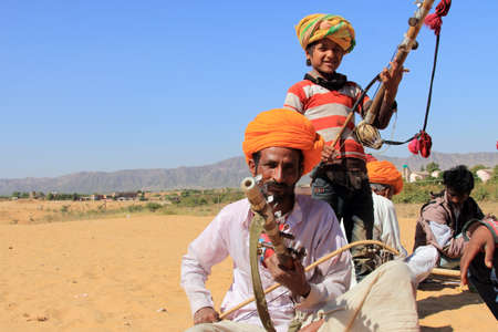 PUSHKAR, INDIA - FEB 5, 2015-Unidentified nomads plays ravanahatha in the deserts in Pushkar, India. Ravanahatha is an ancient instrument used by traditional folk singers in India.のeditorial素材