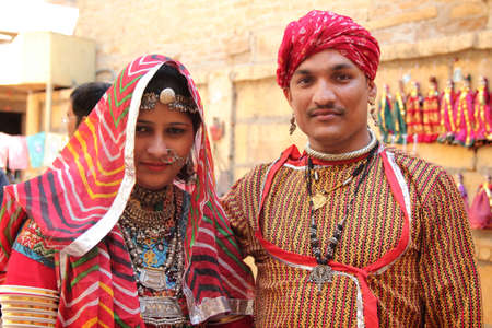JAISALMER, INDIA - FEB 03, 2015-Unidentified Rajasthani couple dressed up in traditional costume and pose in front of a shop during Desert Festival in Jaisalmer, Rajasthan, India.のeditorial素材