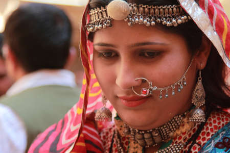 JAISALMER, INDIA - FEB 03, 2015- Unidentified Rajasthani woman dressed up in traditional costume and pose in front of a shop during Desert Festival in Jaisalmer, Rajasthan, India.のeditorial素材