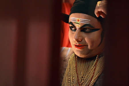 ULLANNOOR, INDIA - FEB 11,2015- An unidentified Kathakali artist does make-up before the on-stage performance during a temple festival in Ullannoor, Kerala,India.のeditorial素材