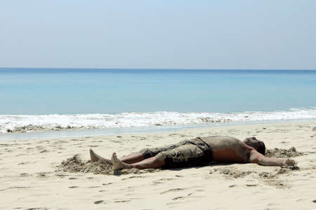 ANDAMANS, INDIA - FEB 13,2012- An unidentified tourist takes mud bath which is considered to be good for the health in the Radha krishna beach in Havelock islands, Andamans,India.のeditorial素材