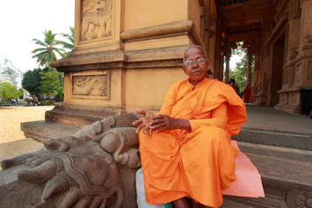 COLOMBO, SRI LANKA - DEC 11,2013- An unidentified Buddhist monk come to do prayers at the Kelaniya Raja Maha Vihara  in Colombo, Sri Lanka.のeditorial素材