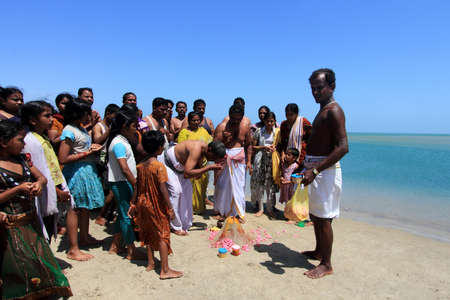 DHANUSHKODI, INDIA - OCT 06,2013- Unidentified Hindu family do rituals at the sacred confluence  in Dhanushkodi, Tamil Nadu, India. Dhanushkodi is a Hindu pilgrimage site in India.のeditorial素材