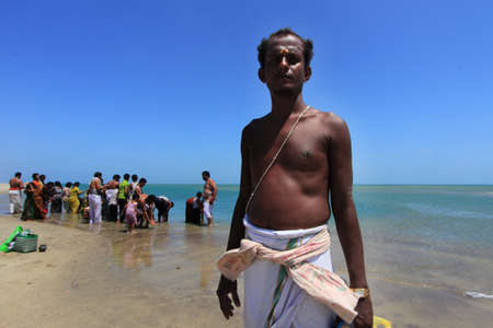 DHANUSHKODI, INDIA - OCT 06,2013- Unidentified Hindu priest do rituals at the sacred confluence in Dhanushkodi, Tamil Nadu, India. Dhanushkodi is a Hindu pilgrimage site in India.のeditorial素材
