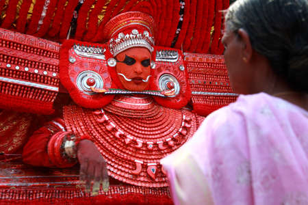 KANNUR - JAN 05,2015-A Theyyam performer gives blessings to a devotee during the annual festival held at Kadannappalli Muchilot Bhagavati temple  in Kannur, IndiaIndiaのeditorial素材