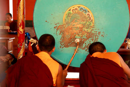 BYLAKUPPE, INDIA - MAR 27, 2015- Buddhist monks beat drums during prayer at Namdroling Monastery  in Bylakuppe,India. Bylakuppe is second largest Tibetan refugee settlement in India.のeditorial素材