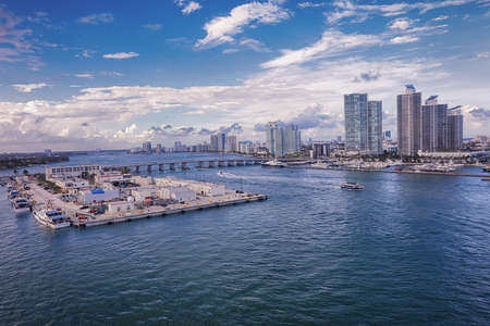 Aerial view of Miami skyscrapers with blue cloudy sky,white boat sailing next to Miami downtownのeditorial素材