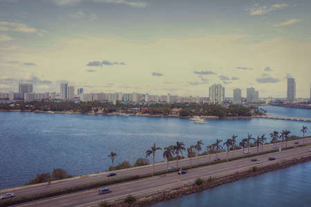 Aerial view of Miami skyscrapers with blue cloudy sky,white boat sailing next to Miami downtownのeditorial素材