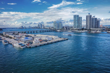 Aerial view of Miami skyscrapers with blue cloudy sky,white boat sailing next to Miami downtownのeditorial素材
