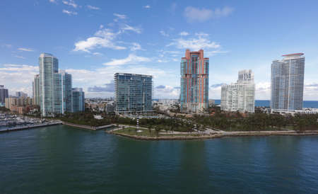 Aerial view of Miami skyscrapers with blue cloudy sky,white boat sailing next to Miami downtownのeditorial素材